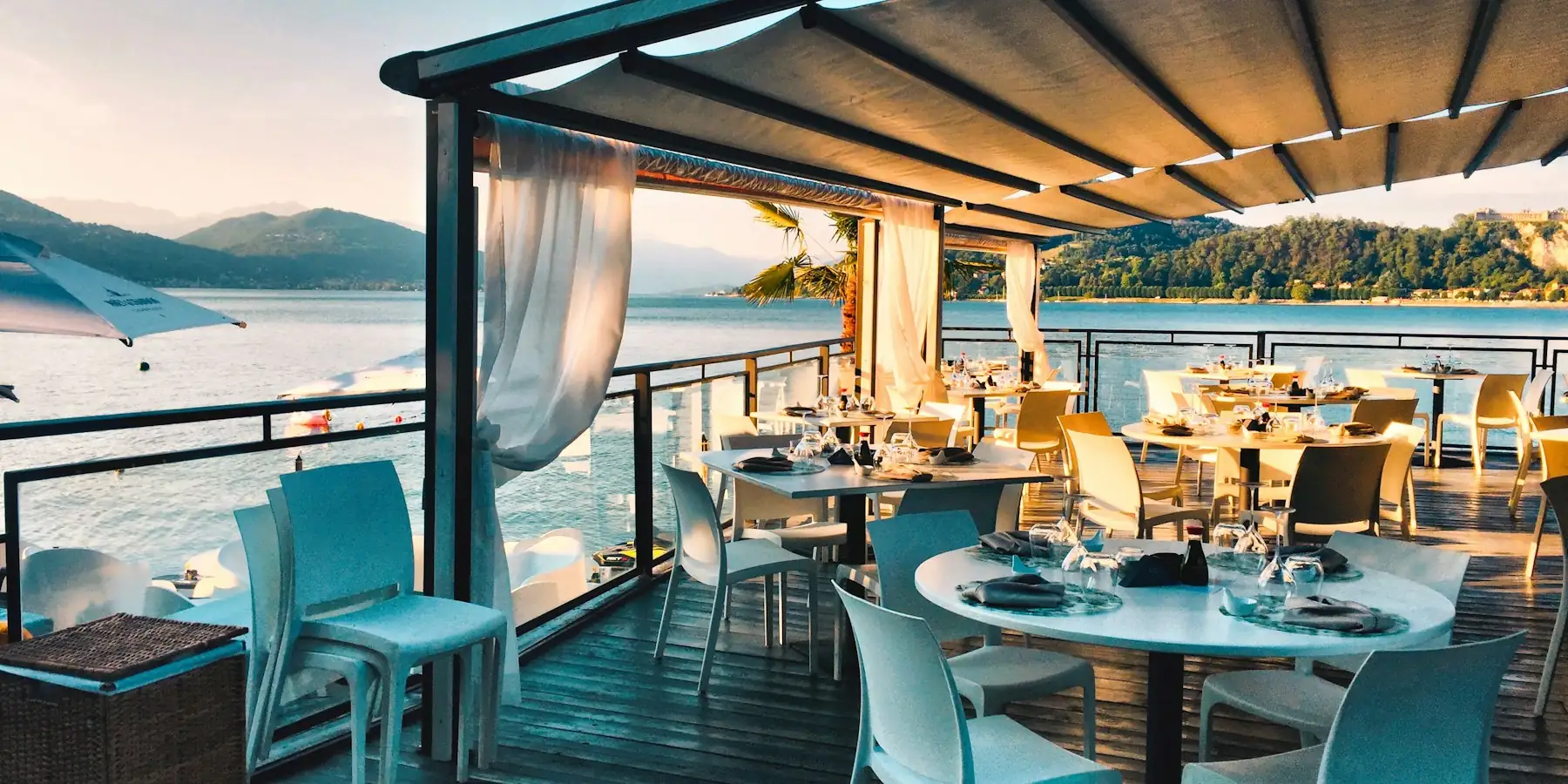 Terrasse de restaurant face à la mer, équipée de tables et de chaises professionnelles
